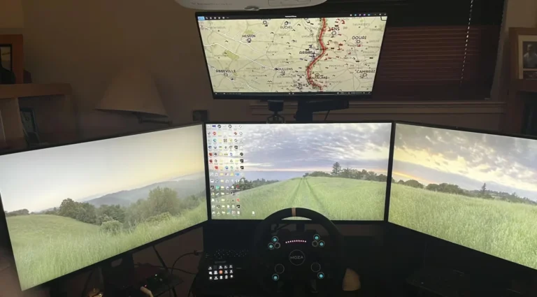 Sim racing desk with triple monitors, wheel and pedals, using a Delanclip Fusion Pro head tracking setup