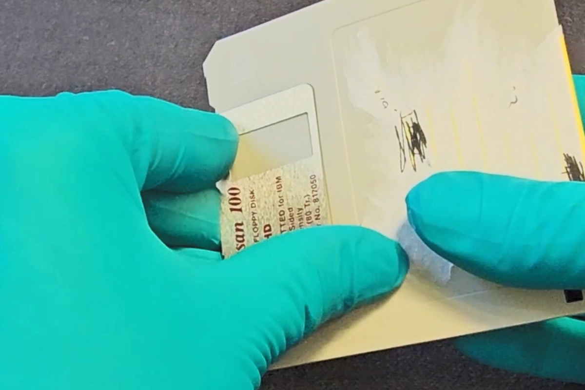 a gloved hand holding a paper